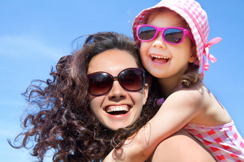 happy little girl and her mom laughing enjoying benefits of great oral health